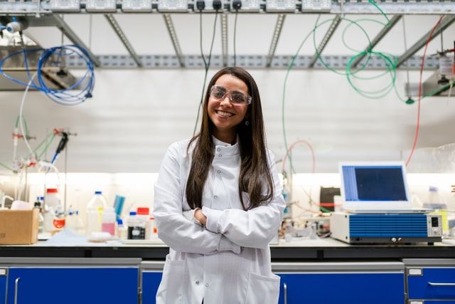 A scientist smiling at the camera in her lab