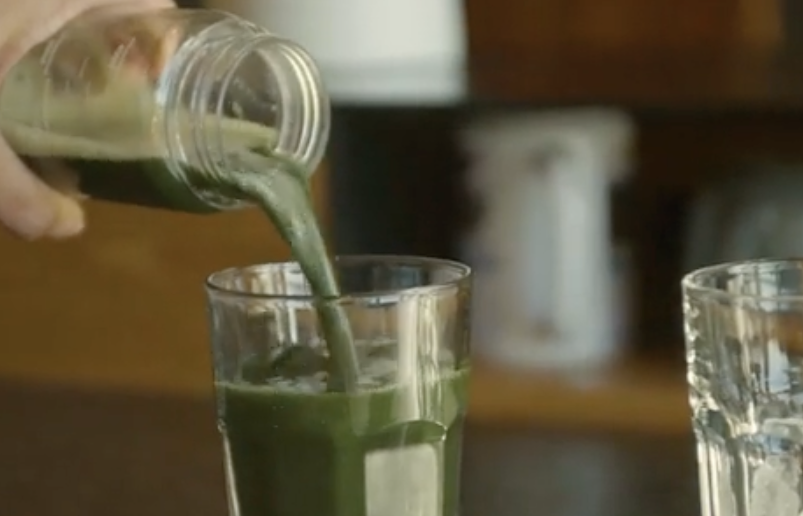 Pouring a glass of green AG1